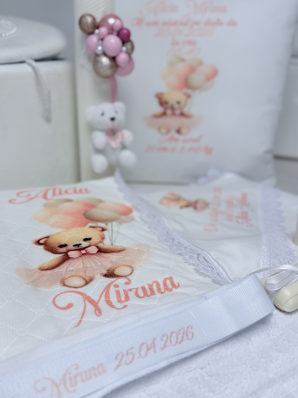 Piesă textilă albă din trusoul de botez, personalizată cu ursuleț balerină, balonașe, numele copilului și data ceremoniei.