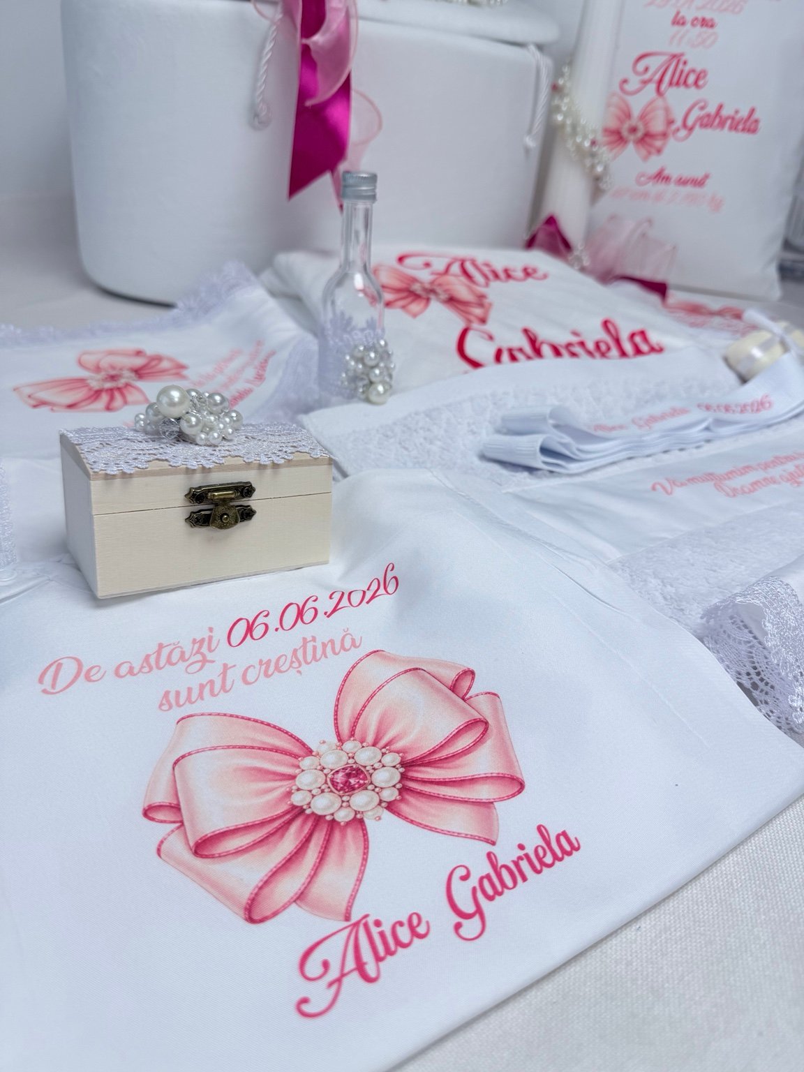 Cutie pentru prima șuviță și sticluță pentru mir cu perle decorative, lângă textile cu fundă ilustrată