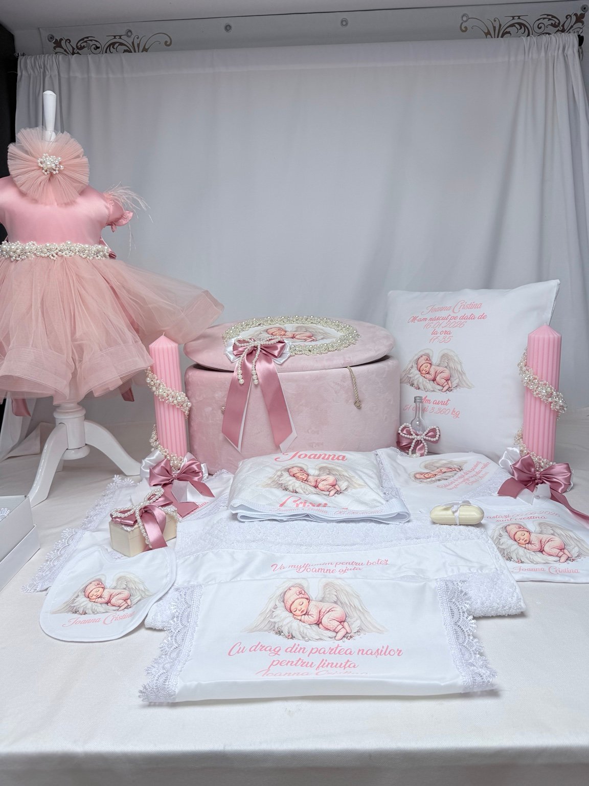Ansamblu de botez PERLA în roz și alb, cu rochiță, cufăr personalizat, textile și două lumânări prezentate