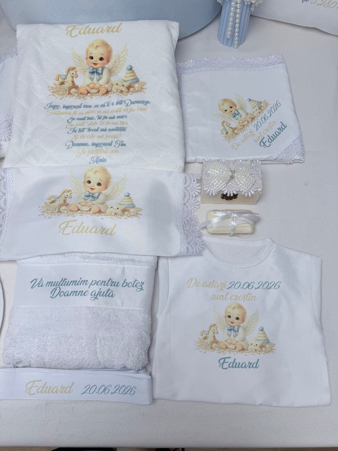 Pătură cu rugăciune, body și textile personalizate cu îngeraș, lângă cutia cu fundă din perle