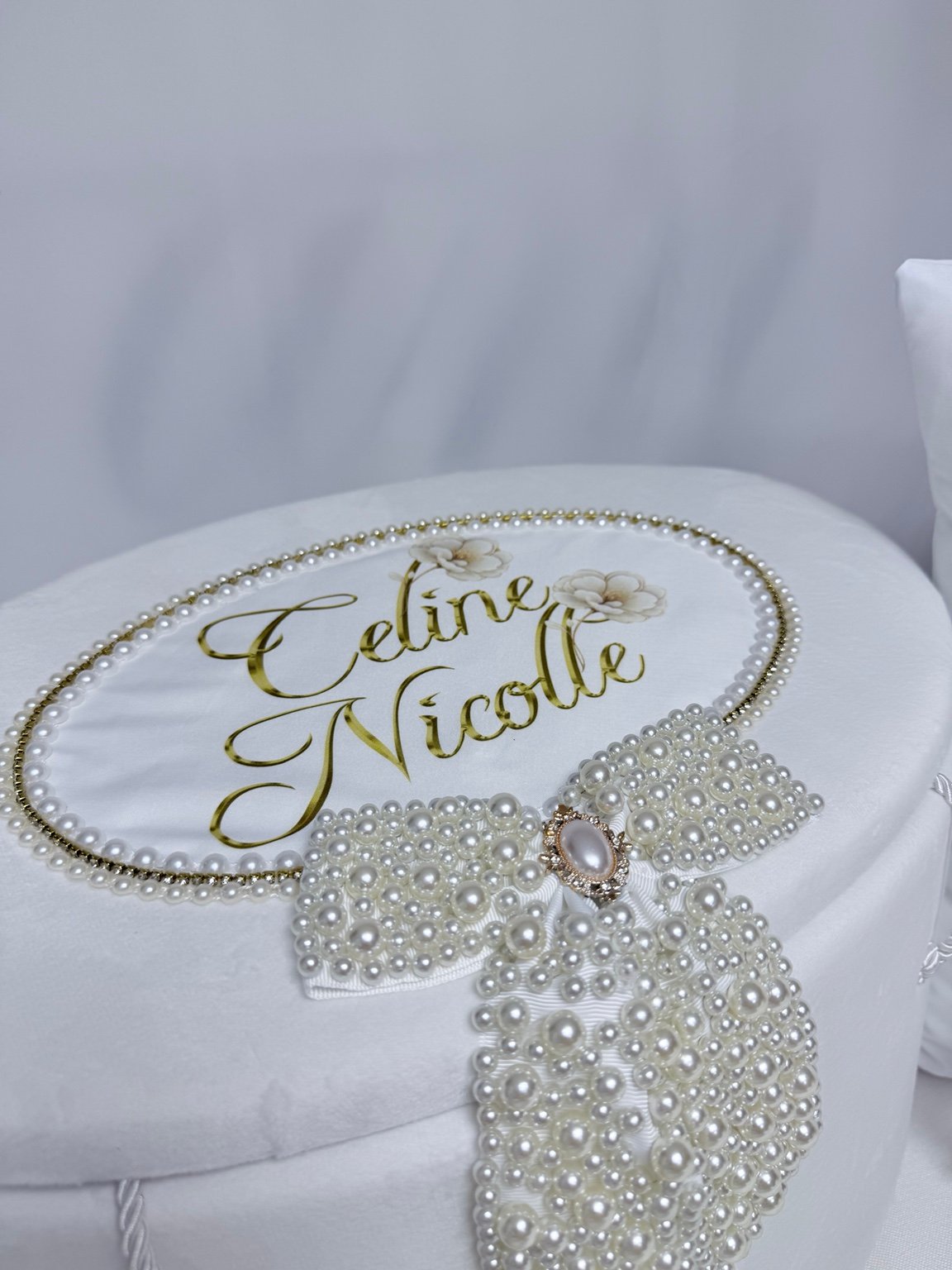 Capacul cufărului personalizat cu nume și flori ilustrate, contur fin de perle și fundă amplă cu ornament oval