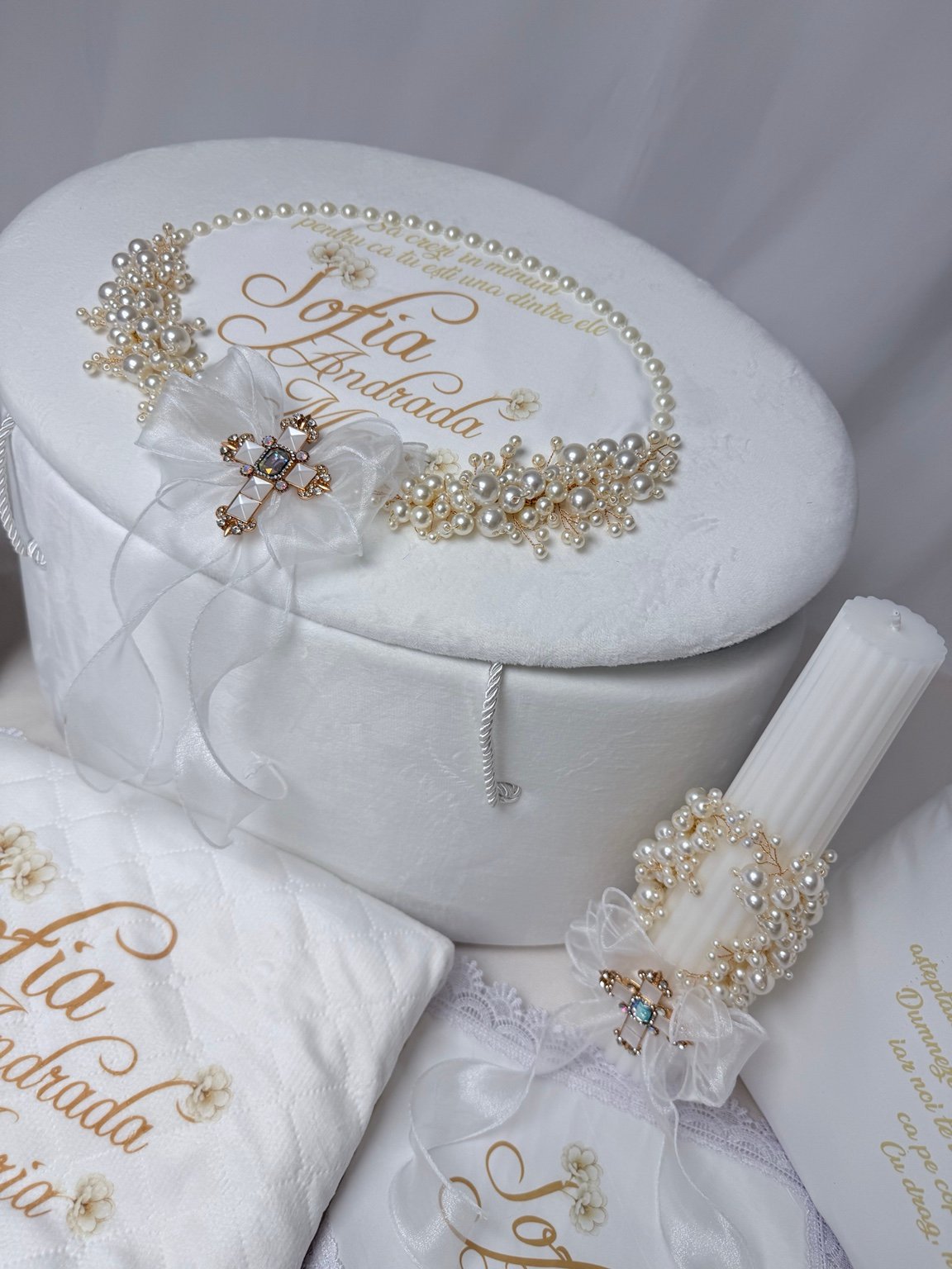 Detaliu al capacului de cufăr personalizat, cu perle decorative, fundă albă și broșă în formă de cruce