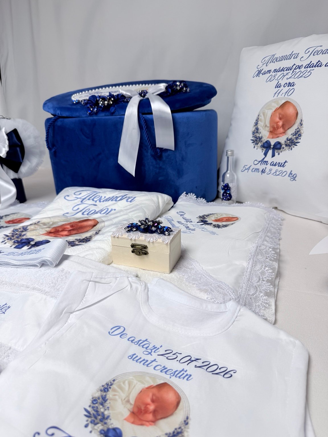Body personalizat cu fotografia bebelușului, lângă cutia pentru prima șuviță cu ornament albastru